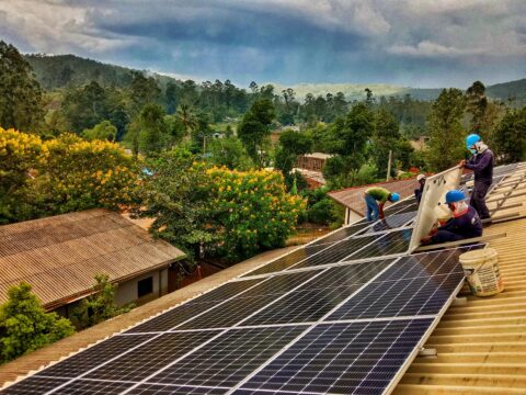 Workers installing solar panels on a rooftop in Sri Lanka